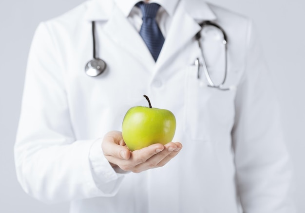 close up of male doctor with green apple