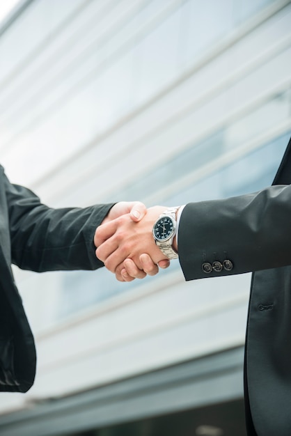 Photo close-up of male and female shaking hands on business deal