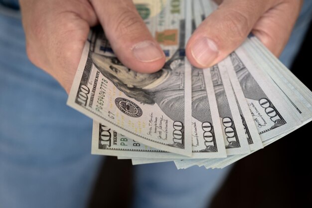 Close up male hand counting and holding money us dollar