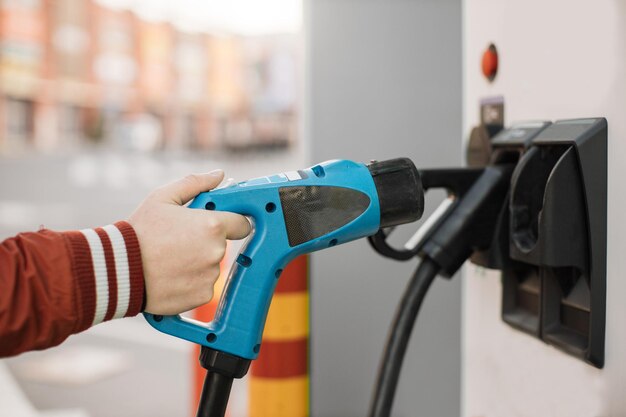 Close up of male hand holding electric charger cord