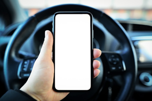 Close-up of male hand holding smartphone with white mockup on screen,