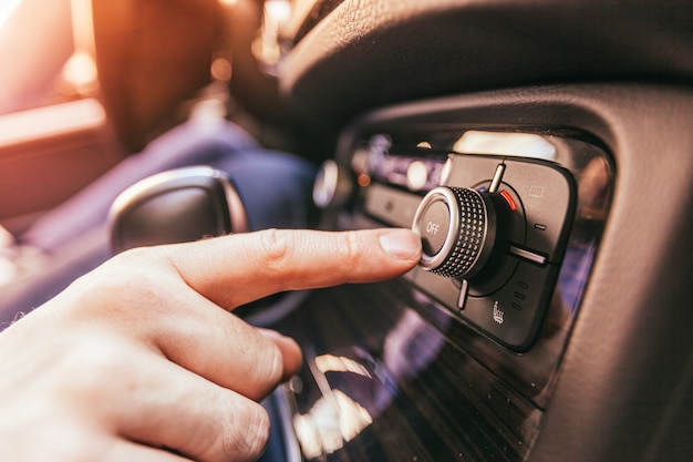 Photo close-up of a male hand  in a modern car