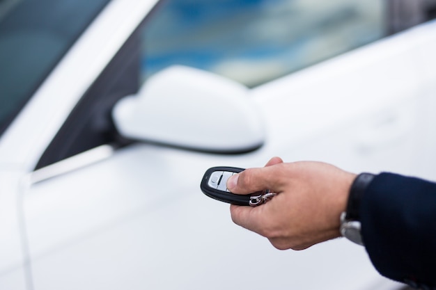 Close up of male hand opening the car door with a remote control