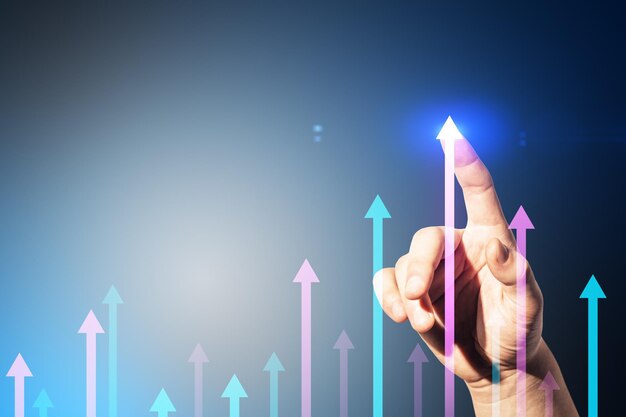 Photo close up of male hand pointing at various growing arrows on gray background with mock up place growth future and performance concept