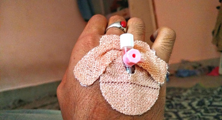 Photo close-up of male hand with catheter