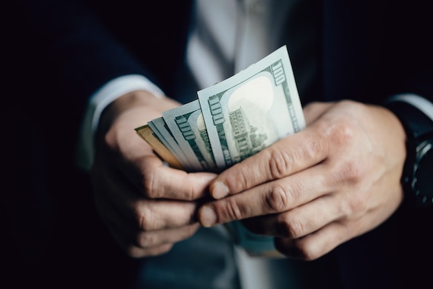 Close up of male hands counting dollar bills