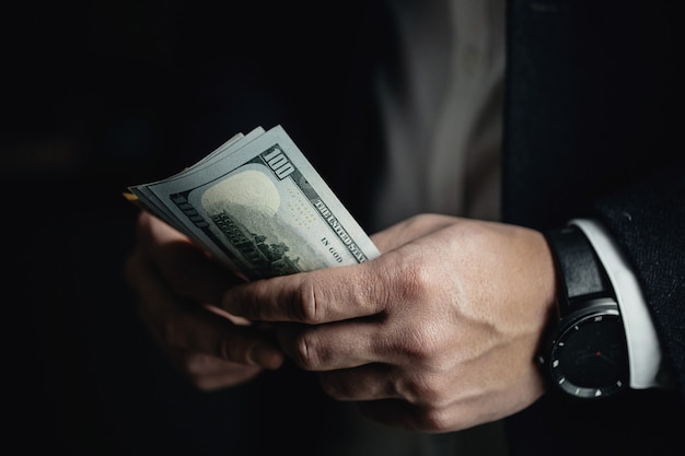 Photo close up of male hands counting dollar bills