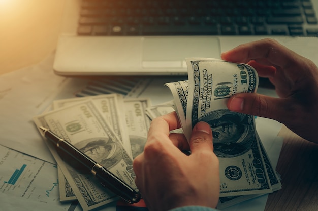 Close up, of male hands counting dollar bills.