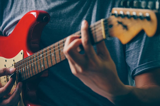 Close up of male hands playing electric guitar. Selective focus