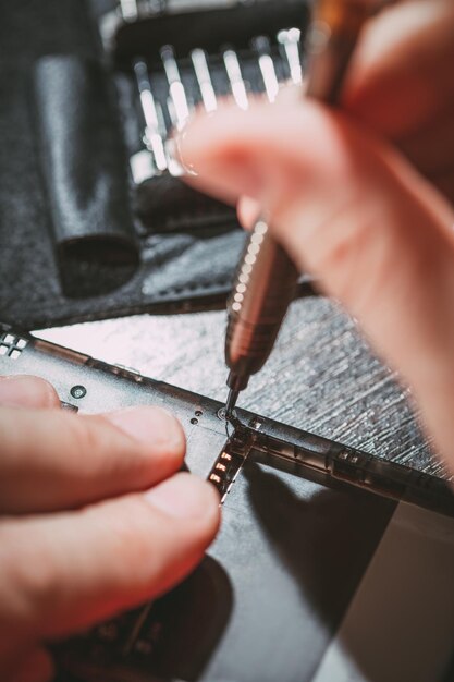 Photo close-up of a male hands servising broken smartphone.