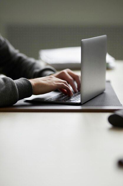 Photo close-up male hands typing on a laptop keyboard. office work. working on a laptop