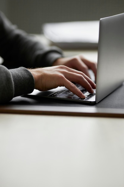 Photo close-up male hands typing on a laptop keyboard. office work. working on a laptop