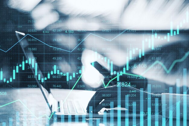 Close up of male hands using laptop and cellphone with glowing business chart hologram and index on blurry background Finance trade and invest concept Double exposure