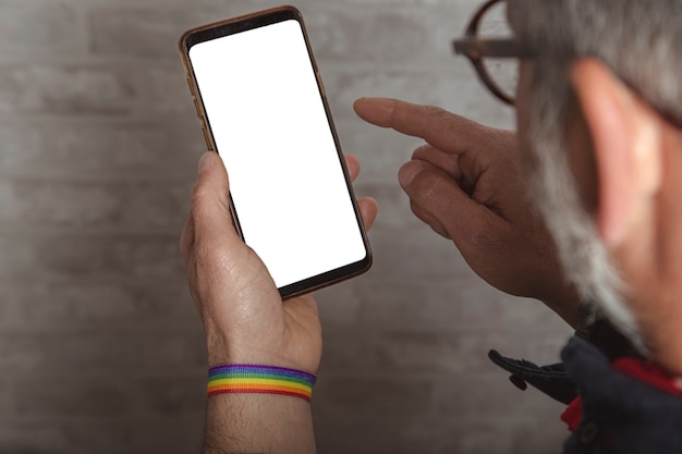 スマートフォンを使用してlgbtブレスレットと男性の手のクローズアップ