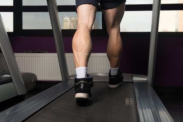 Primo piano di gambe maschili in esecuzione sul tapis roulant movimento sfocato