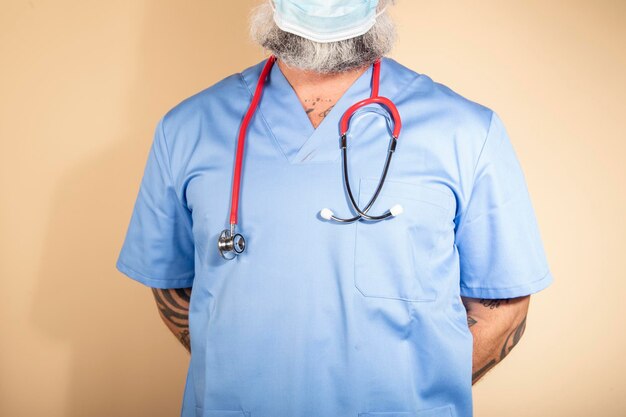 Close up of a male nurse wearing blue gown and mask isolated