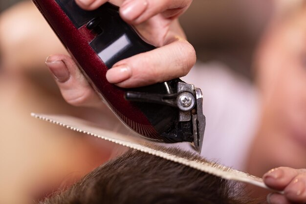 Foto primo piano di uno studente maschio che ha un taglio di capelli con le tosatrici