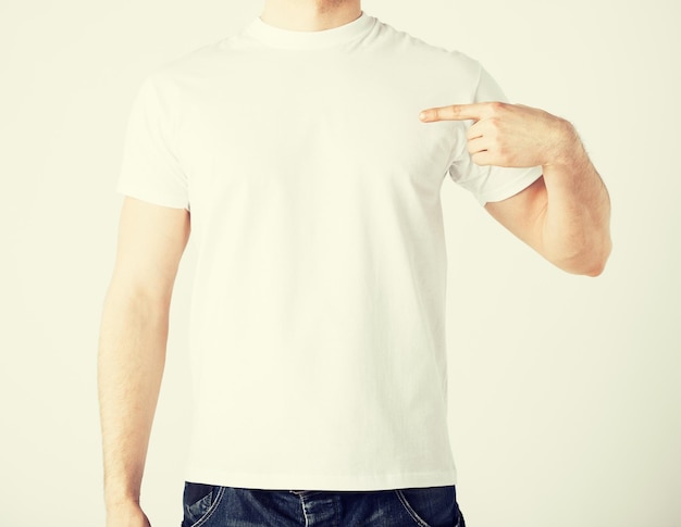 close up of man in blank t-shirt pointing at himself