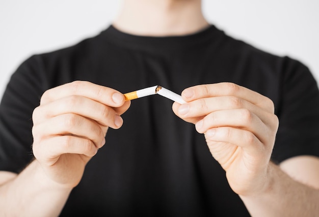 close up of man breaking the cigarette with hands