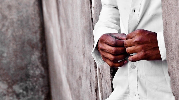 Foto close-up di un uomo che abbottona la camicia