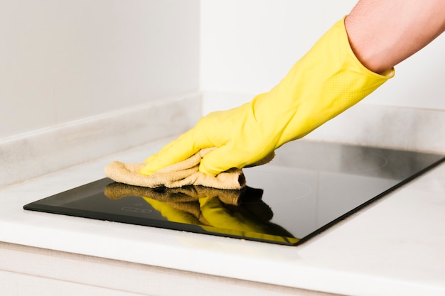 Photo close up man cleaning induction stove