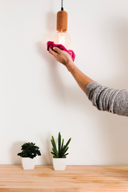 Photo close up man cleaning light bulb