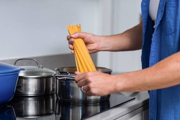 close-up of man cooking spaghetti