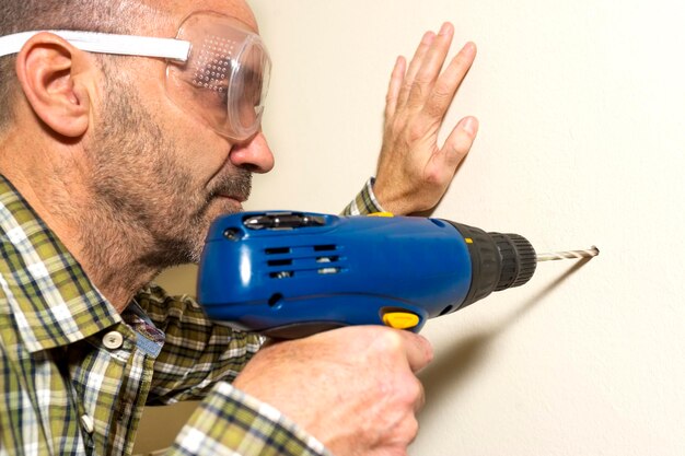 Photo close-up of man drilling wall