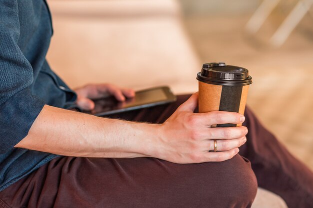 オフィスでコーヒーを飲む人のクローズアップ