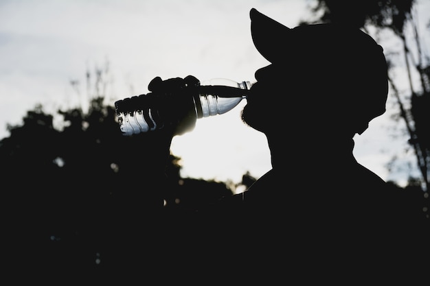 Close up of a man drinking water from a bottle after exercise.