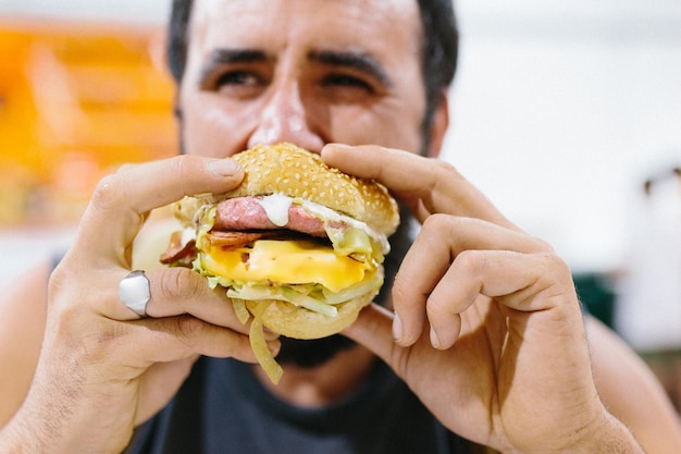 Close-up of man eating burger