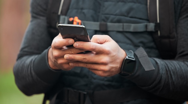 Close-up man en hardloper met een mobiele telefoon typen en verbinding met het bijhouden van voortgangsnetwerk of contact Persoon hardloper of handen met digitale app-smartphone of breken met fitness en sociale media