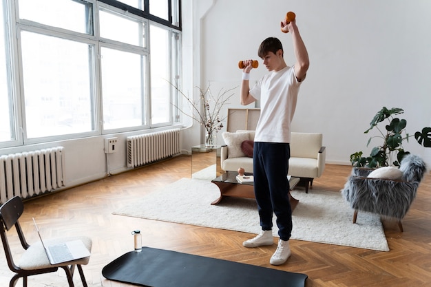 Close up on man exercising after online instructor