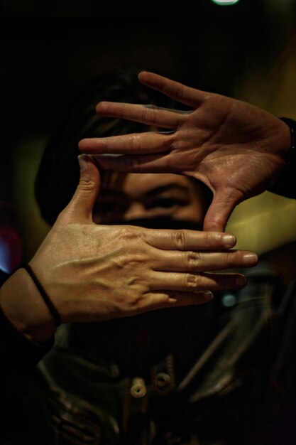 Photo close-up of man gesturing in darkroom