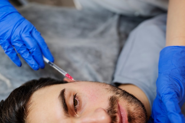 Close up man getting hyaluronic acid injection