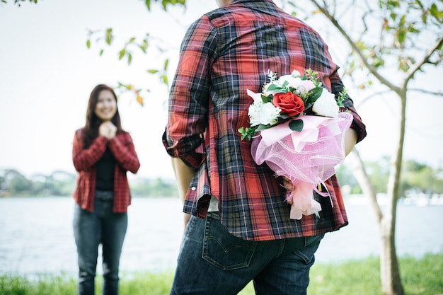 Il primo piano di un uomo che dà i fiori felici della donna. un'immagine di una coppia romantica che ottiene.