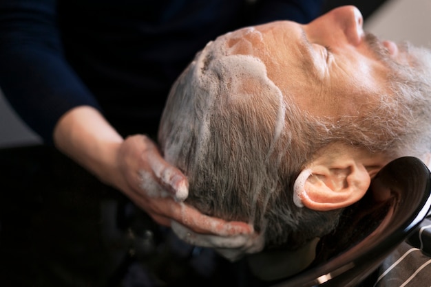 Foto close-up man haar wassen in salon