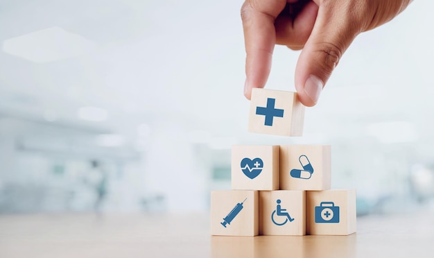 Photo close up man hand arranging wood block with healthcare medical icon on hospital background