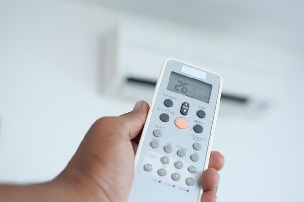 Close up of man hand holding air condition remote