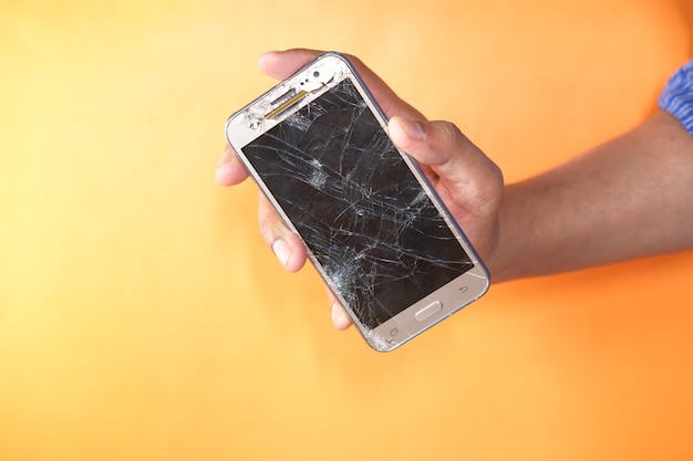 Close up of man hand holding broken smart phone