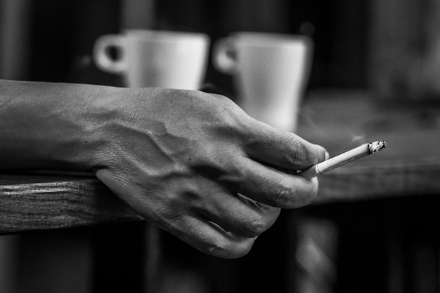 Foto close-up di un uomo con la mano che tiene una sigaretta