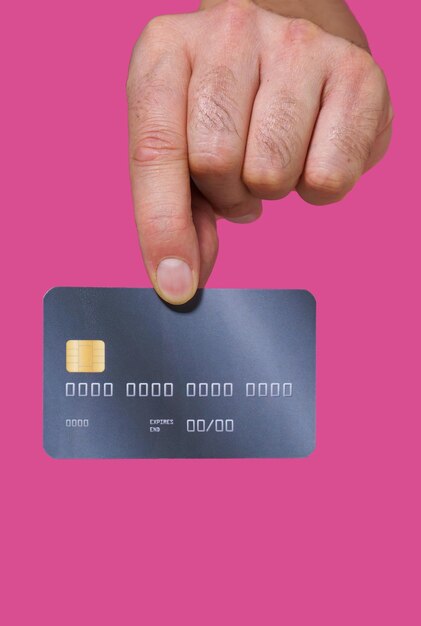 Close up man hand holding credit debit bank card with two fingers Male hand with credit card Plastic banking card in man hand isolated on pink background