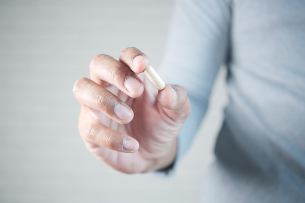 Close up of man hand holding pills with copy space