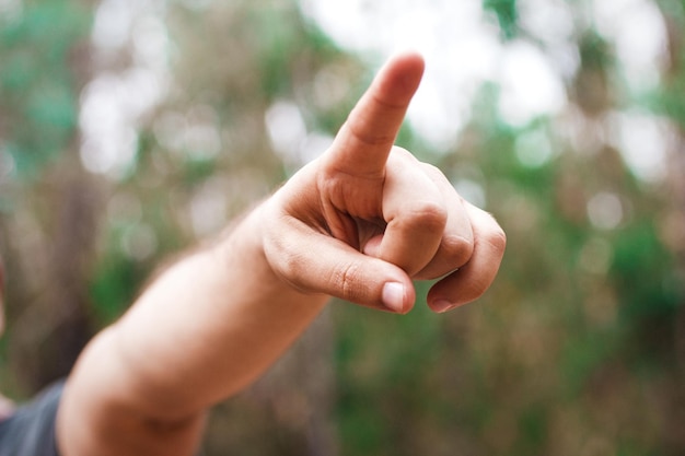 Close-up of man hand pointing in park