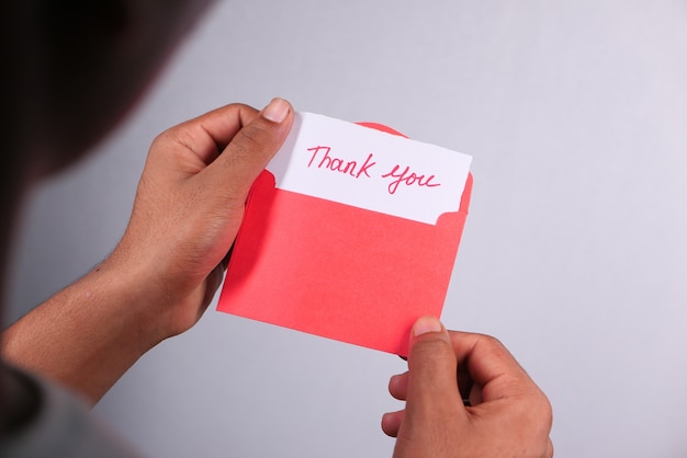 close up of man hand reading a thank you letter