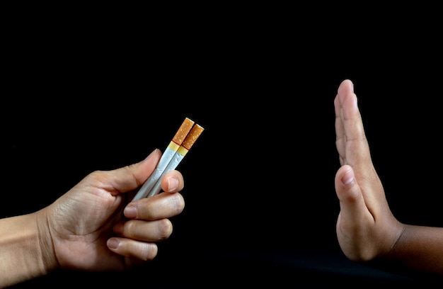 Close up Man hand Reject cigarette offer on black background. 