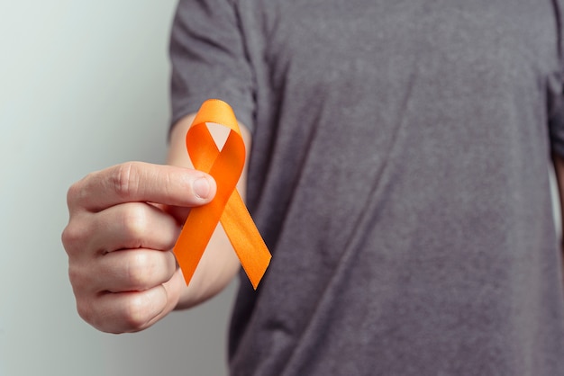 Photo close up on man hand showing ribbon for awareness