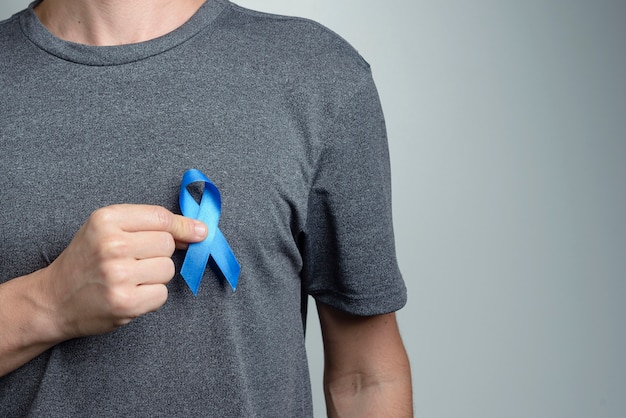 Close up on man hand showing ribbon for awareness