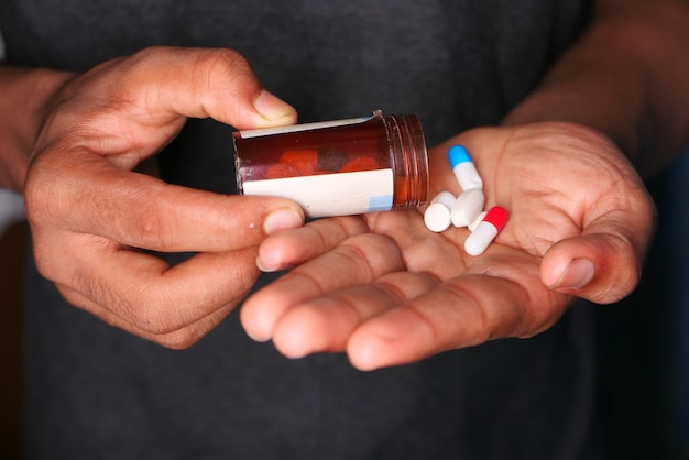 Close up of man hand taking medicine .