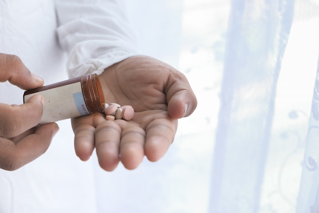 Close up of man hand taking medicine
